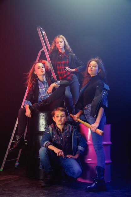 Rebel youth. Full length portrait of cocky children in stylish jeans and leather clothes. Concept of teenage riot, kids fashion, nonconformism and young energy. Modern lifestyle.