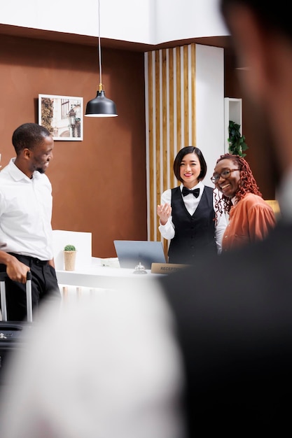 La receptionist chiama il cameriere per aiutare.