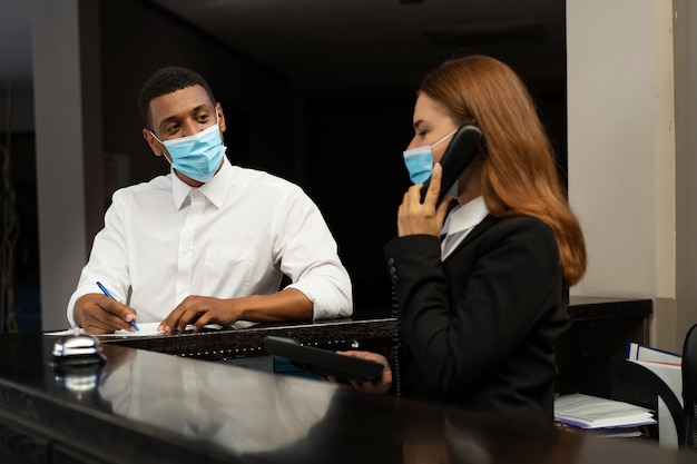 Foto gratuita receptionist in abito elegante durante l'orario di lavoro con il cliente