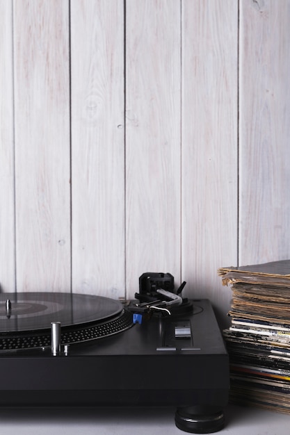 Record player and discs near white wall