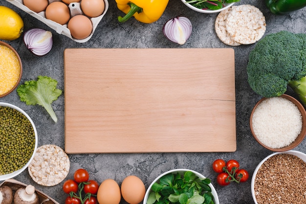 健康的な野菜に囲まれた長方形の木製まな板