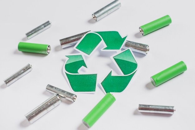Recycle icon on batteries over white background