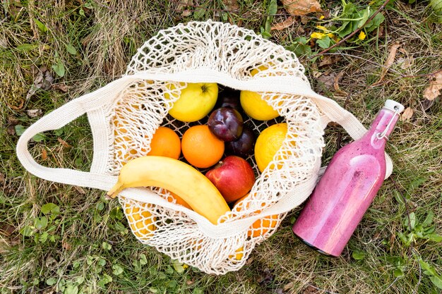 Recycling bag and smoothie on grass