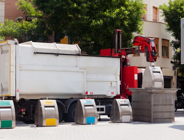 Foto gratuita riciclaggio camion raccogliendo bidone in città