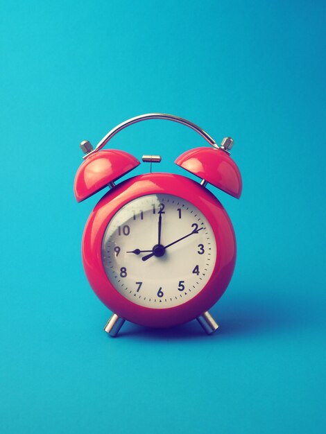 Red alarm clock on blue background