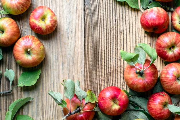 Free photo red apple and leaf on wooden table