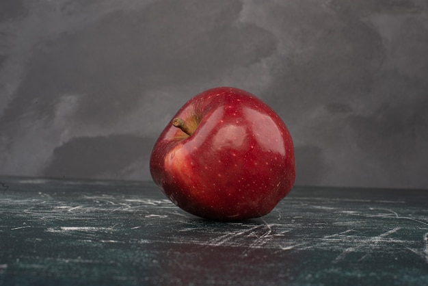 Red apple on marble background .