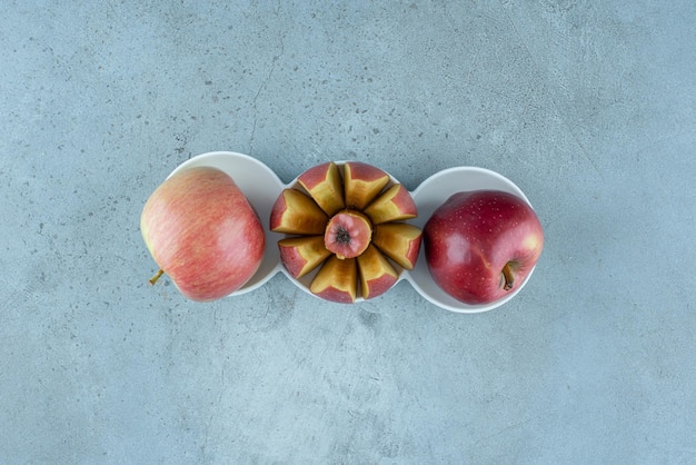 Free photo red apples inside white ceramic cups.