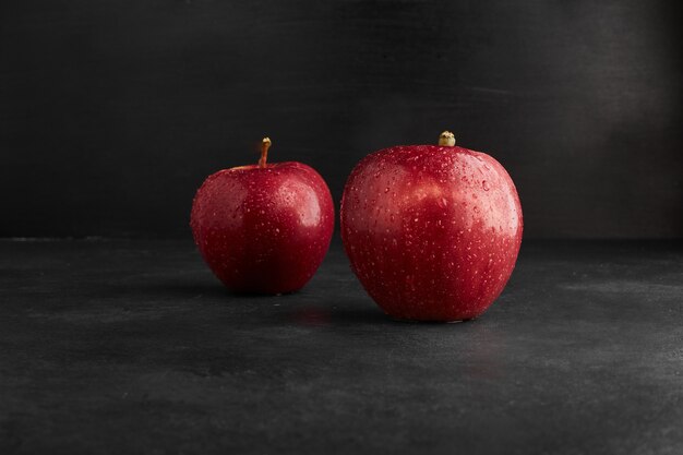 Red apples isolated on black surface. 