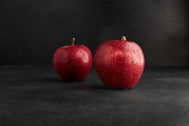 Red apples isolated on black surface. 