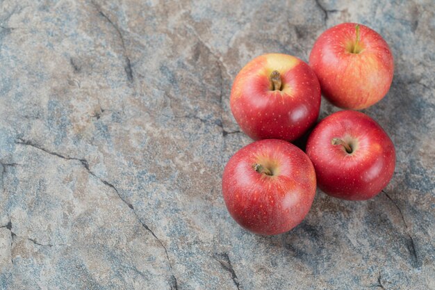 Red apples isolated on grey marble.