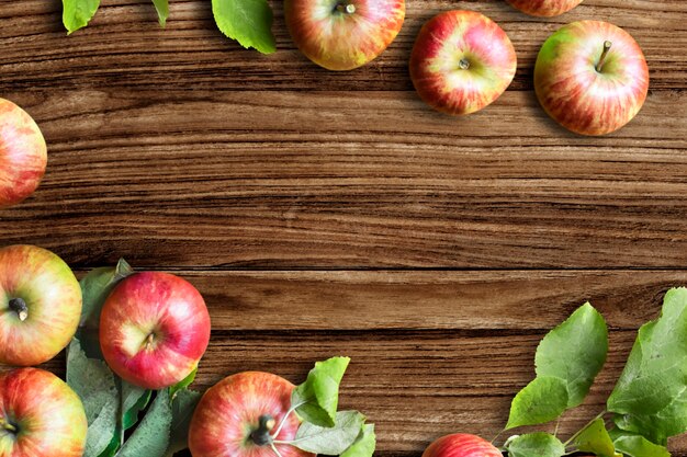 Red apples and leaves flat lay wooden table