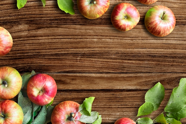 Red apples and leaves flat lay wooden table