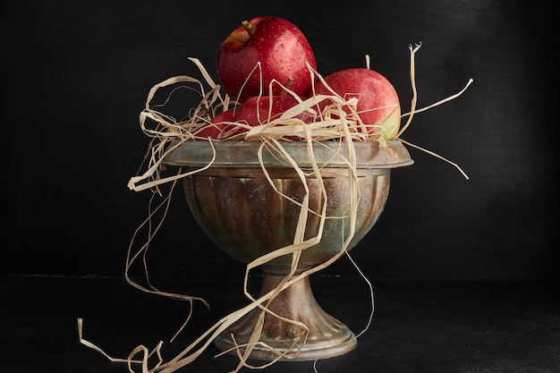 Red apples in a metallic cup. 