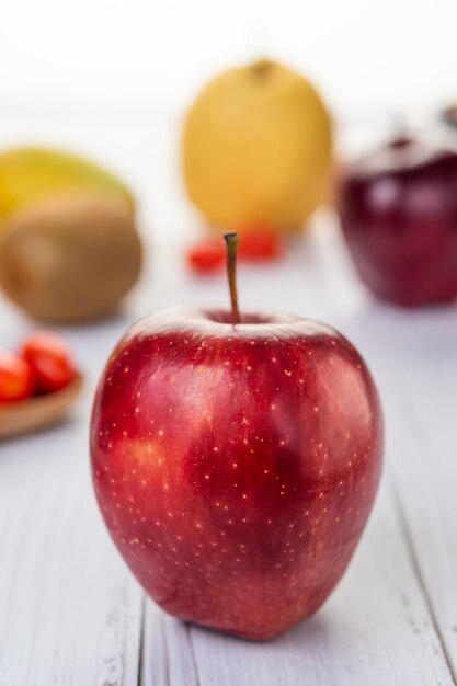 Red apples placed on the wooden floor.