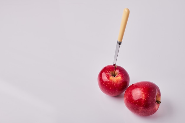 Red apples with a knife on them 
