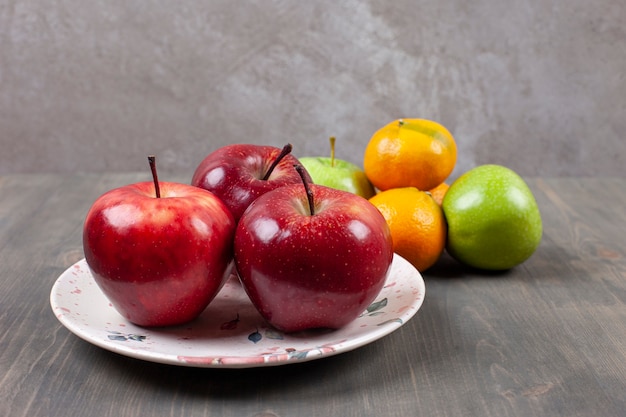 나무 테이블에 귤과 빨간 사과입니다. 고품질 사진
