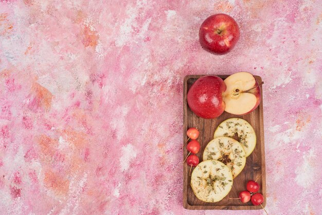 Red apples on wooden board.
