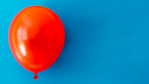 Red balloon on blue background with copy space