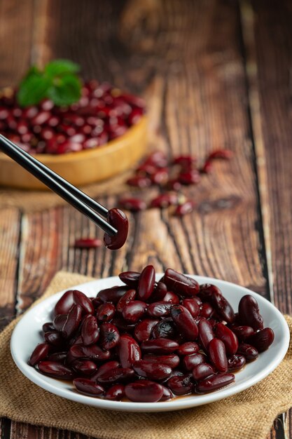 red bean boiled in white plate place on wooden floor