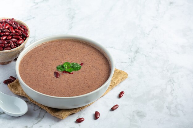 red bean hot soup in white bowl place on white marble floor