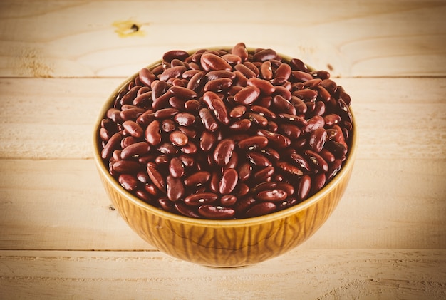 Free photo red  beans on wood background - soft focus with vintage film filter