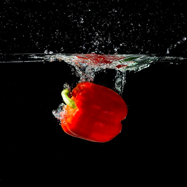 Red bell pepper splash into clear water