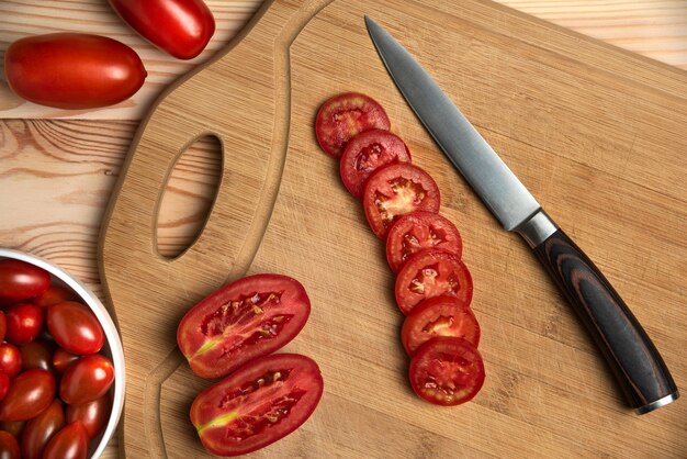 Red berries and sliced tomatoes on the wooden table