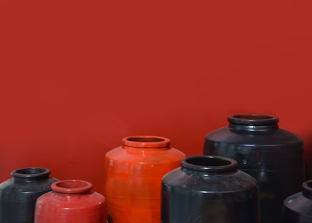 Free photo red and black ceramic jar on red background