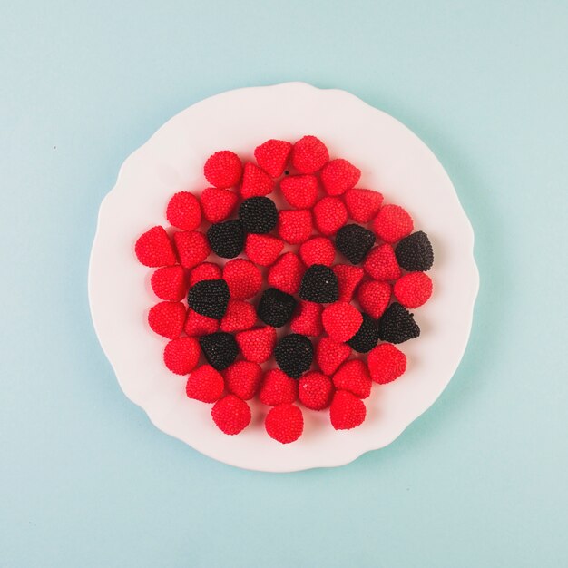 Red and black cranberry candies on plate