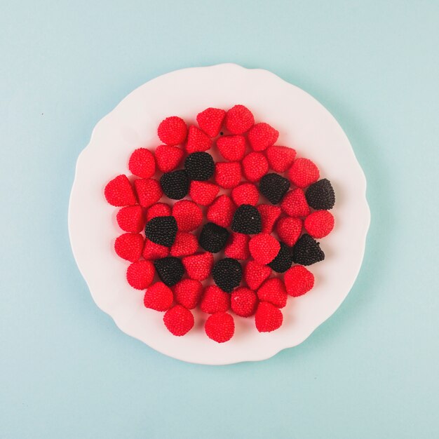 Красные и черные клюквенные конфеты на тарелке