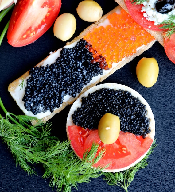 Red and black crispy cracker sandwiches with vegetables. Top view.