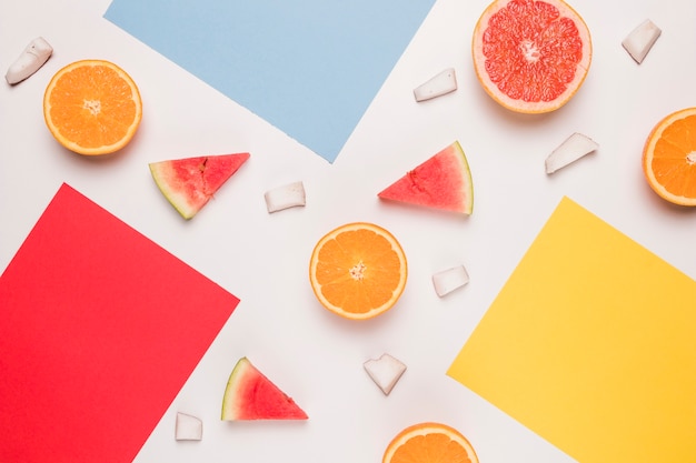 Red blue yellow sticky note and sliced watermelon orange grapefruit coconut