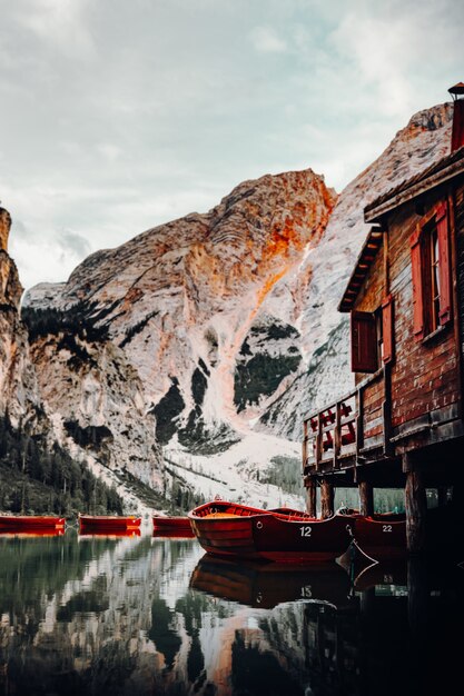 Красная лодка на водоеме возле коричневого деревянного дома в дневное время