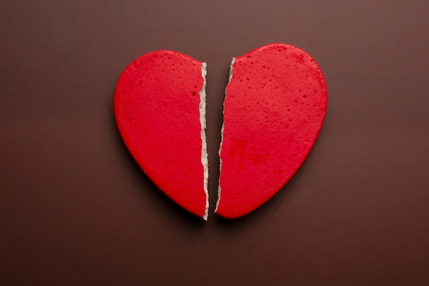 Red broken heart on brown background