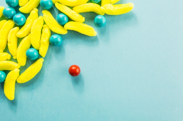 Red candy drop near pile of sweets