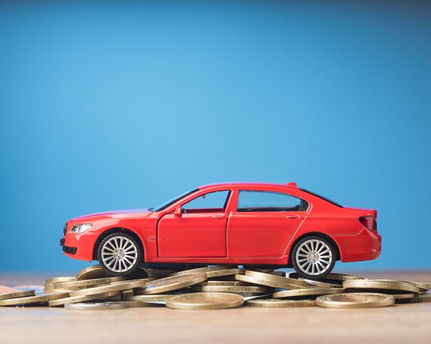 Red car on a bunch of coins