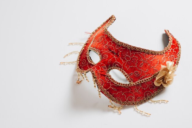 Красная карнавальная маска на светлом столе