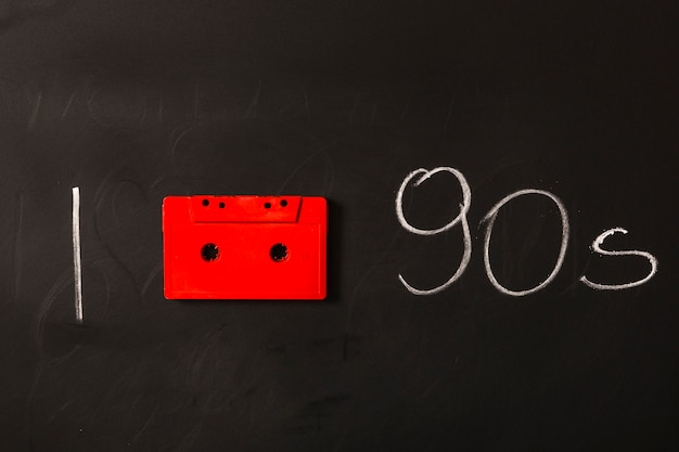 Free photo red cassette tape with nineties written on blackboard