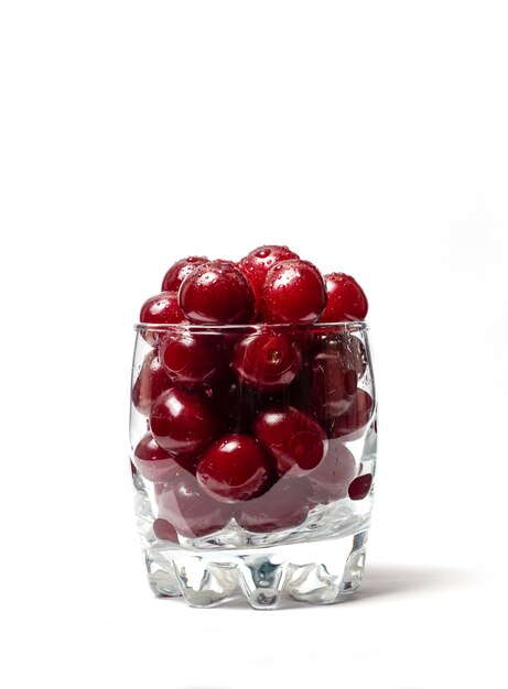 Красные вишни в стеклянной чашке, изолированные на белом фоне