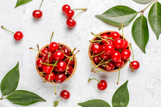 Red cherries in plate bowl on gray table