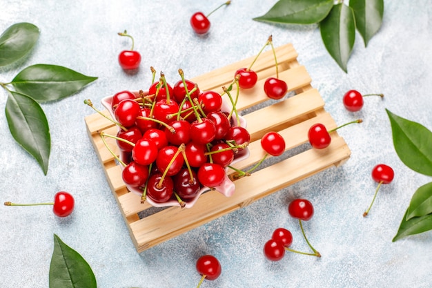 Red cherries in plate bowl on gray table