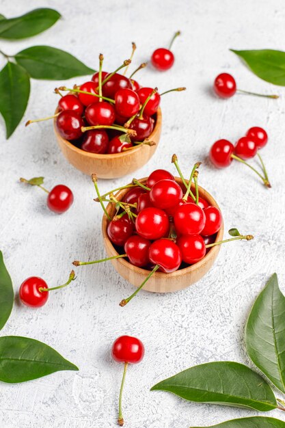 Red cherries in plate bowl on gray table