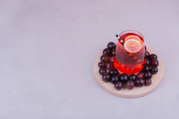 灰色のジュースのガラスと赤い桜の果実。