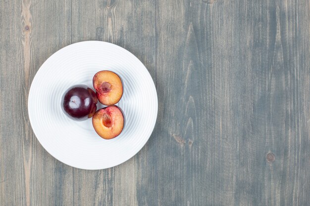 Red cherry plum isolated on a white plate