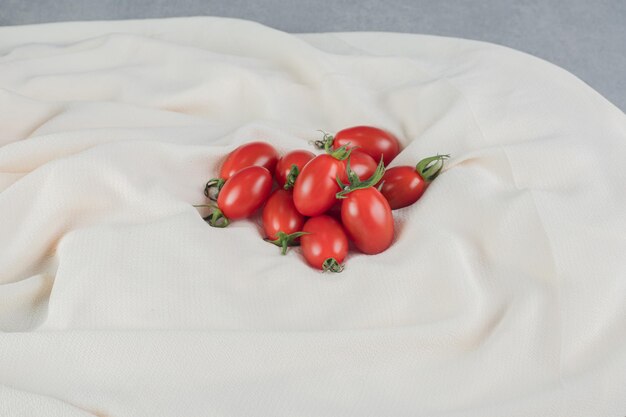 Red cherry tomatoes isolated on concrete table.