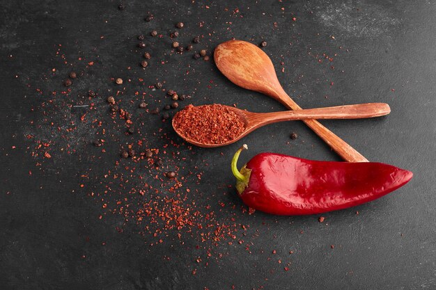 Red chili pepper with paprika in a wooden spoon.