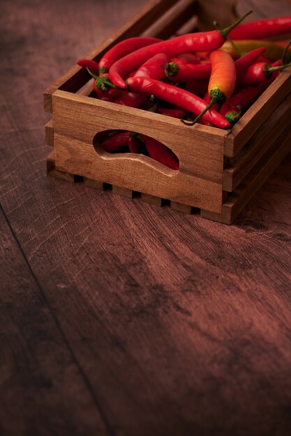 Red chili peppers in a box put on a wooden surface