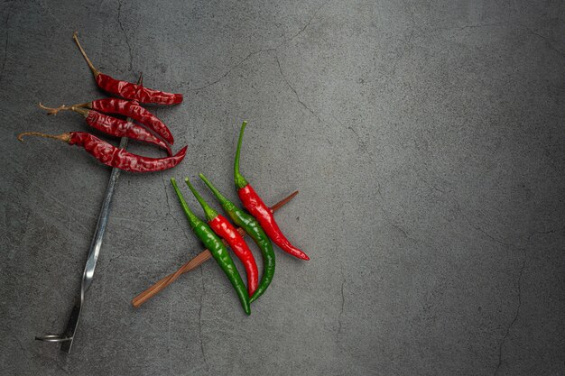 Red chilli has a skewer on black.