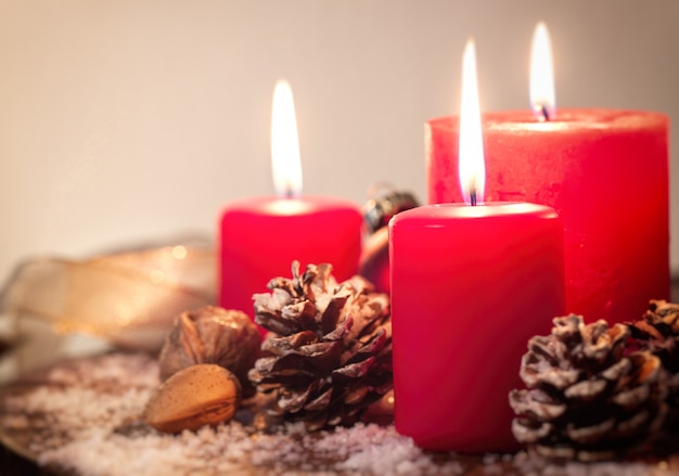 Free photo red christmas candles with fir cones